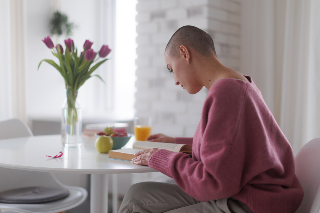 Young Woman with Cancer Reading Book, Cancer Awareness Concept.